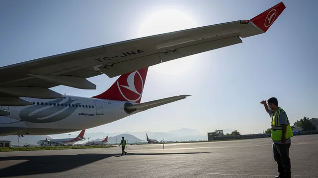Turkish Airlines flight is evacuated via emergency slides after smoke was detected in the landing gear